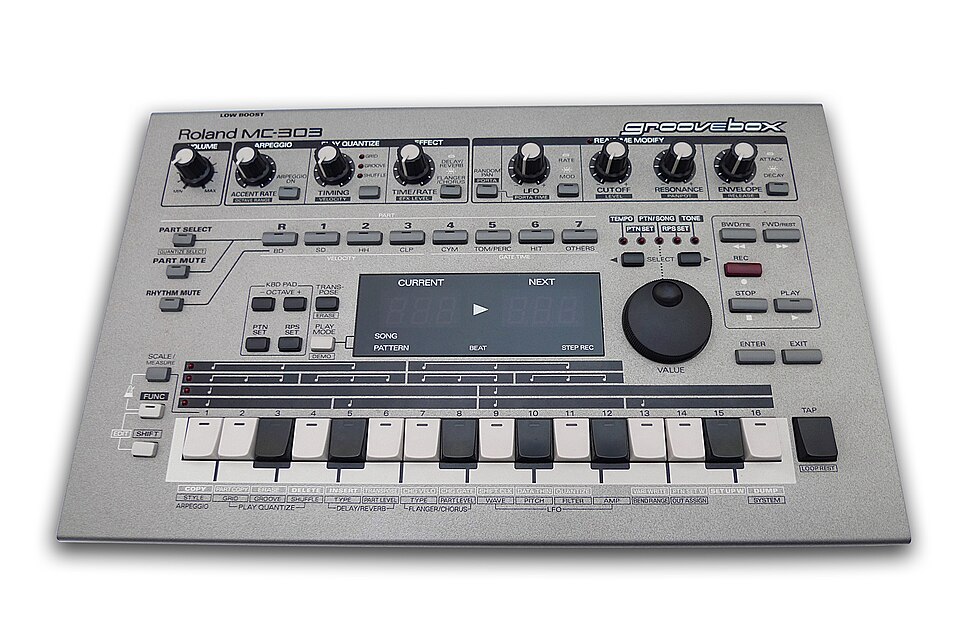 Roland MC-303 Groovebox from 1996, a silver desktop unit with knobs, a 16-step key row and the word groovebox printed on the panel